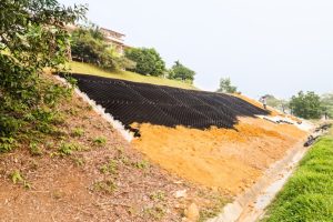 Slope erosion control with grids and earth on steep slope.